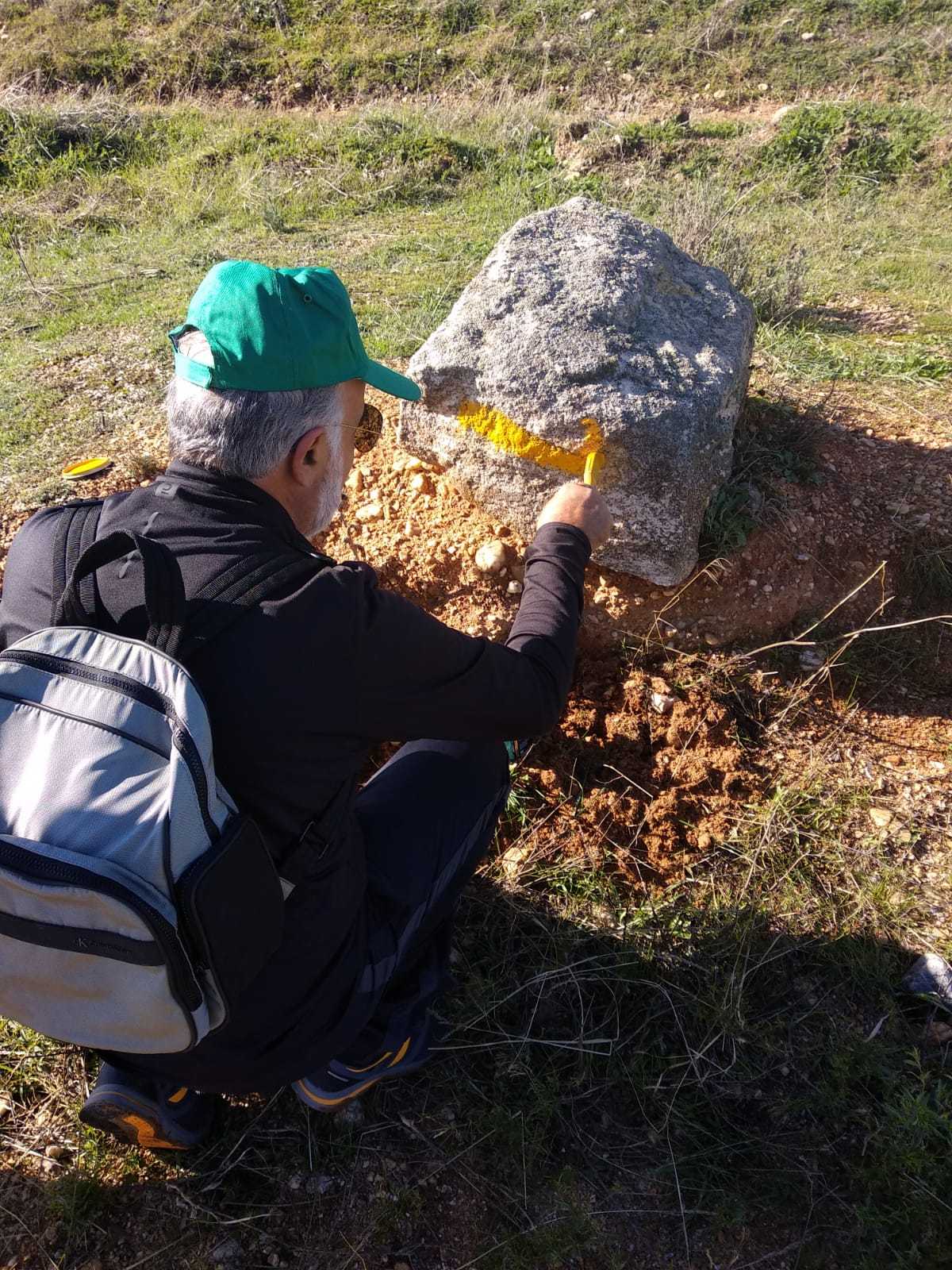 Un voluntario repinta una señal del Camino de Santiago en Zamora